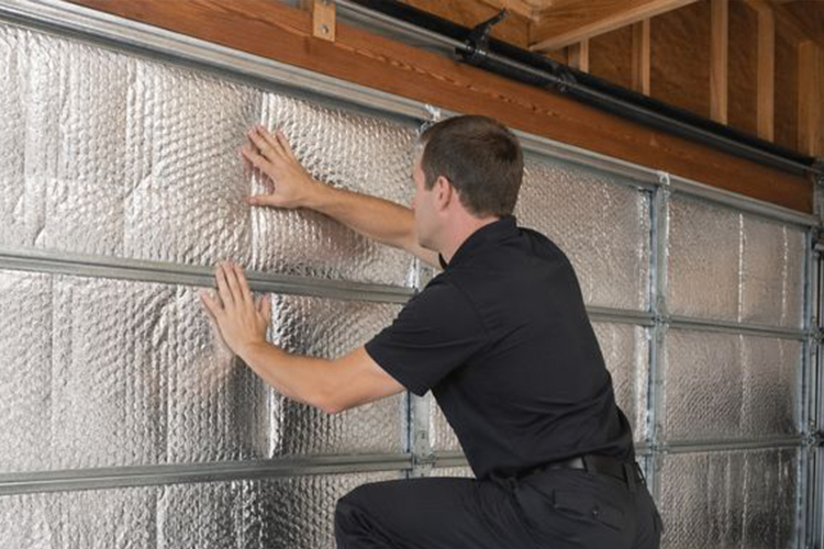 Garage door insulation installation with technician in black uniform